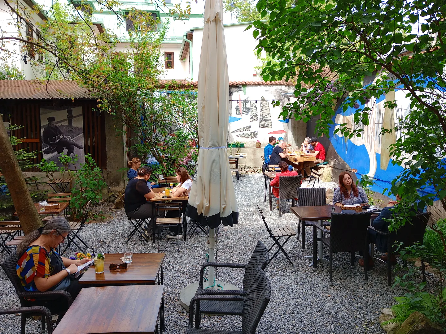 Outdoor tables among the courtyard planting at 2 Okna Café