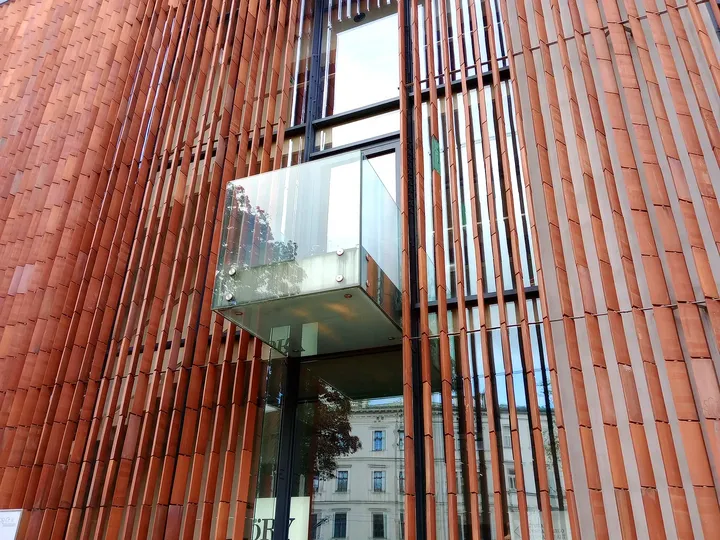 Modern red entrance detail at All Saints Square, Kraków