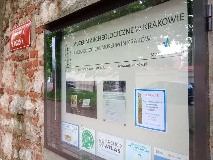 Museum notices beside the brick boundary wall at Archaeological Museum, Kraków