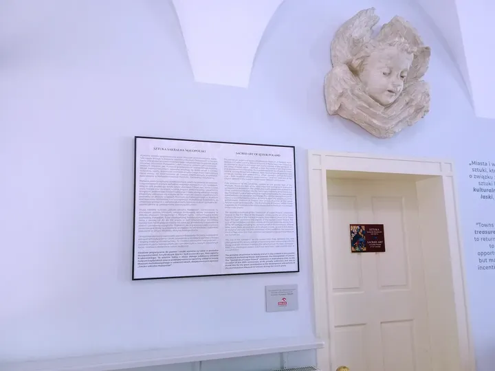 An explanatory panel beside a displayed relief at Archdiocesan Museum, Kraków