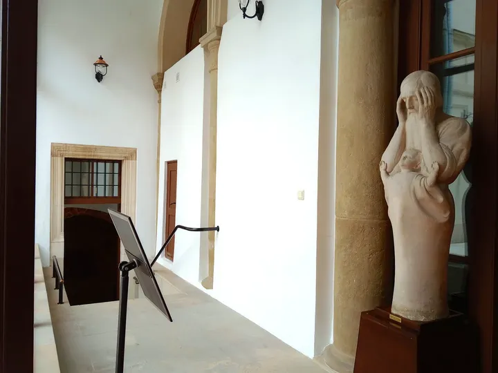 A sculpture beside a museum window at Archdiocesan Museum, Kraków