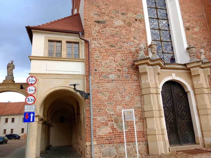 The arched approach beside the tower at Assumption Church, Żagań