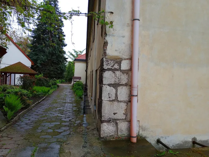 The passage beside a pale building at Bernardine monastery garden