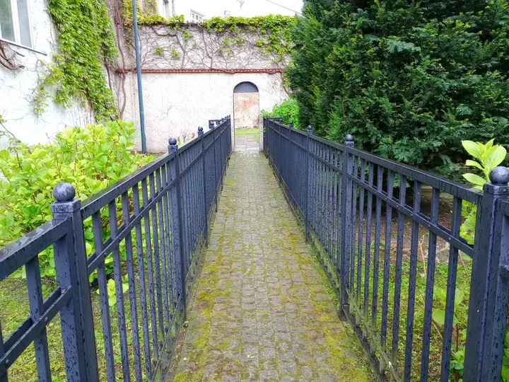 The narrow garden passage and railing at Bernardine monastery garden