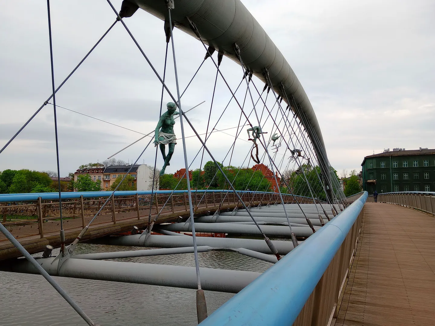 Suspended figures along the footbridge at Between Water and Sky sculptures