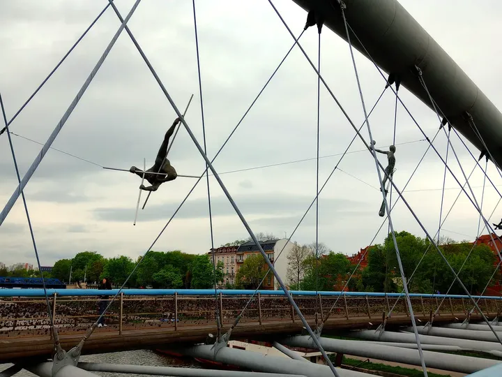 Suspended figure beside the upper bridge beam at Between Water and Sky sculptures