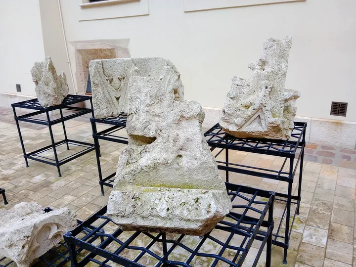 Stone fragments beside the courtyard at Bishop Erazm Ciołek Palace