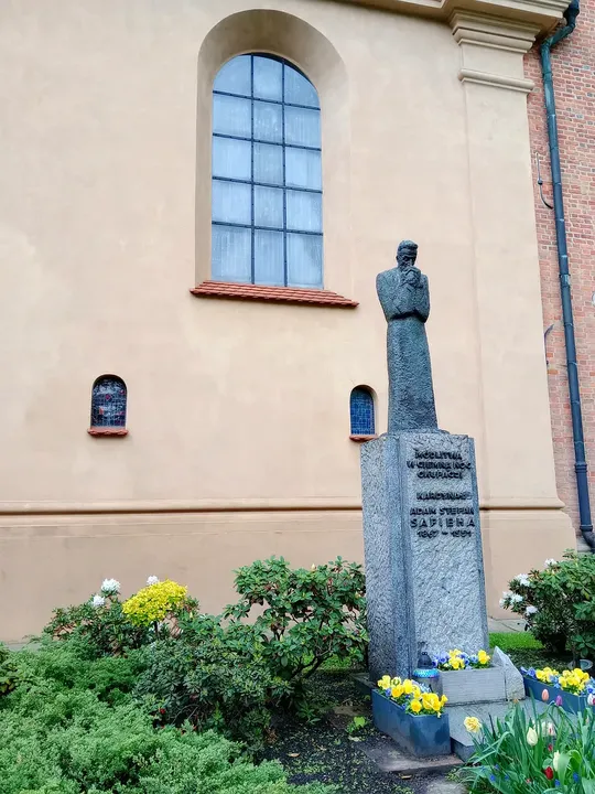 The monument beside planted flower beds at Cardinal Adam Sapieha monument