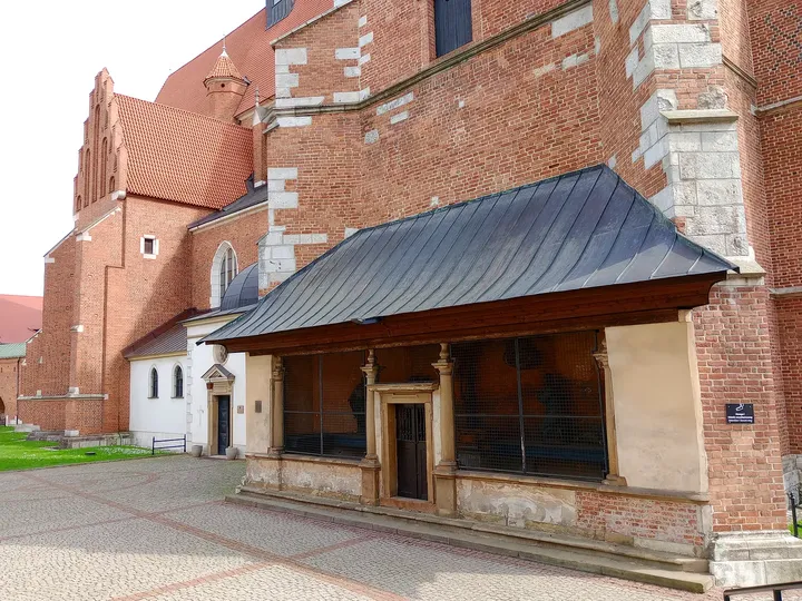 Brick apse beside a small tiled porch at Corpus Christi Basilica, Kraków