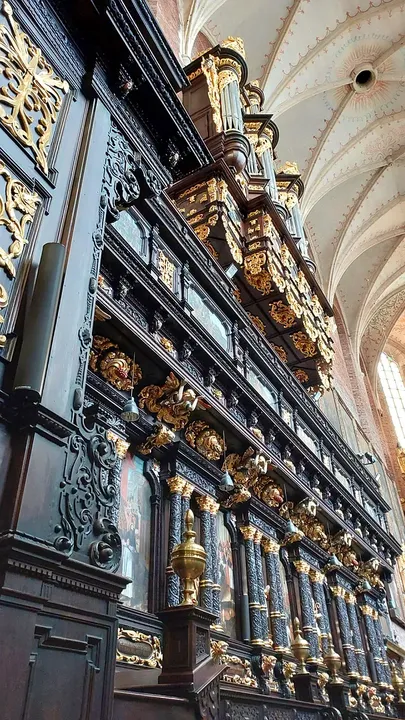 Row of dark carved choir stalls at Corpus Christi Basilica, Kraków