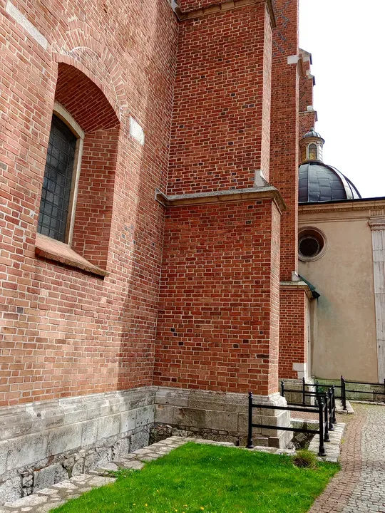 Tall brick wall above a stone base at Corpus Christi Basilica, Kraków