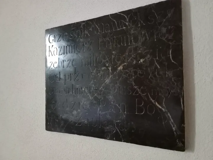 A dark commemorative tablet at Dominican monastery, Kraków