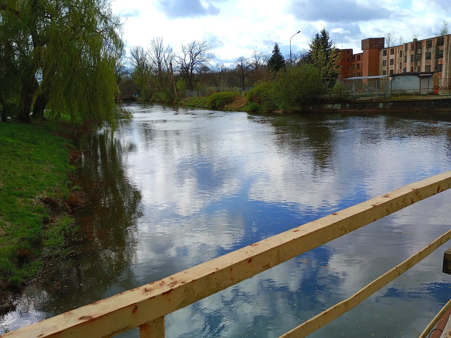 Water and trees beyond the railing at Duchess Dorota riverside walk, Żagań