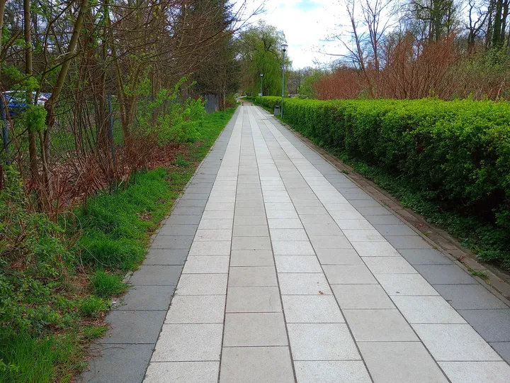 Long paved walkway beside the greenery at Duchess Dorota riverside walk, Żagań