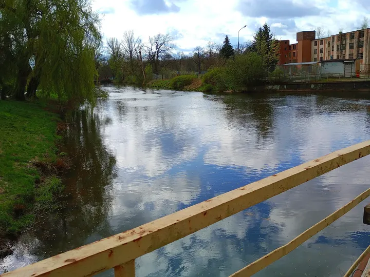 Water and trees beyond the railing at Duchess Dorota riverside walk, Żagań