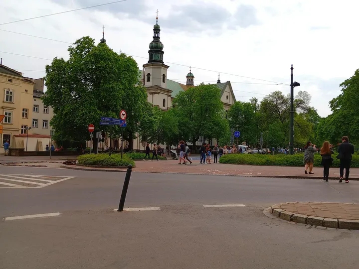 The open space and trees beside the road at Father Adam Studziński Square