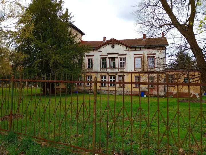 Building beyond the fenced green space at Former Protestant church tower, Żagań