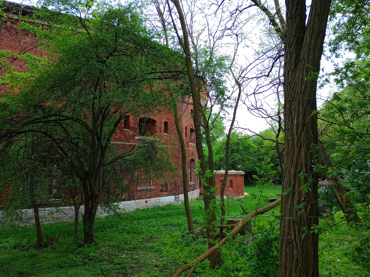 Rounded brick exterior through the greenery at Fort 31: Saint Benedict