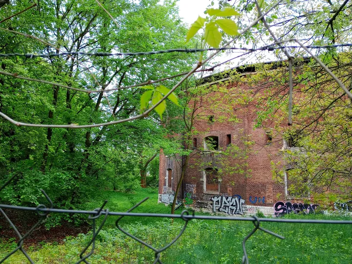 Fort wall behind the boundary fence at Fort 31: Saint Benedict
