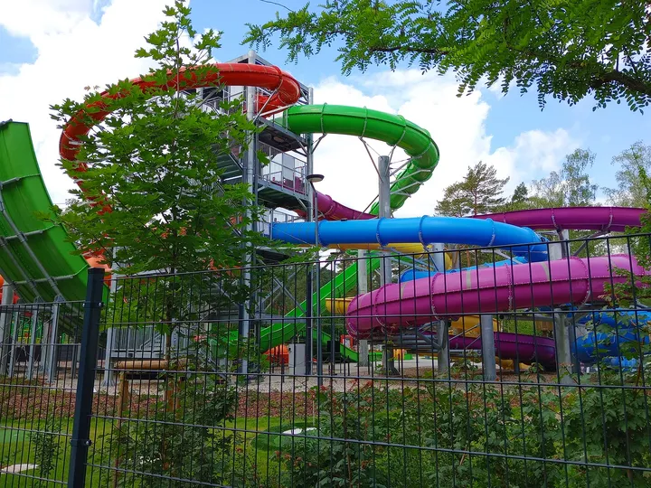 Colourful slides seen through the trees at H2Ochla swimming lake