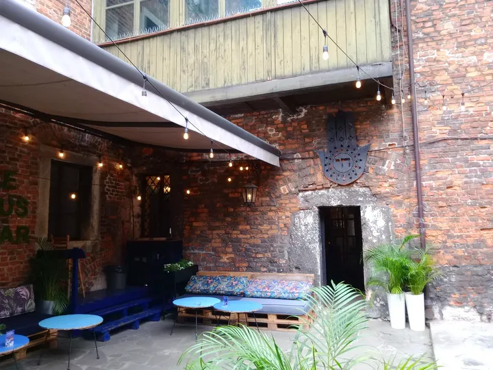Courtyard tables beside the brick walls at Hamsa
