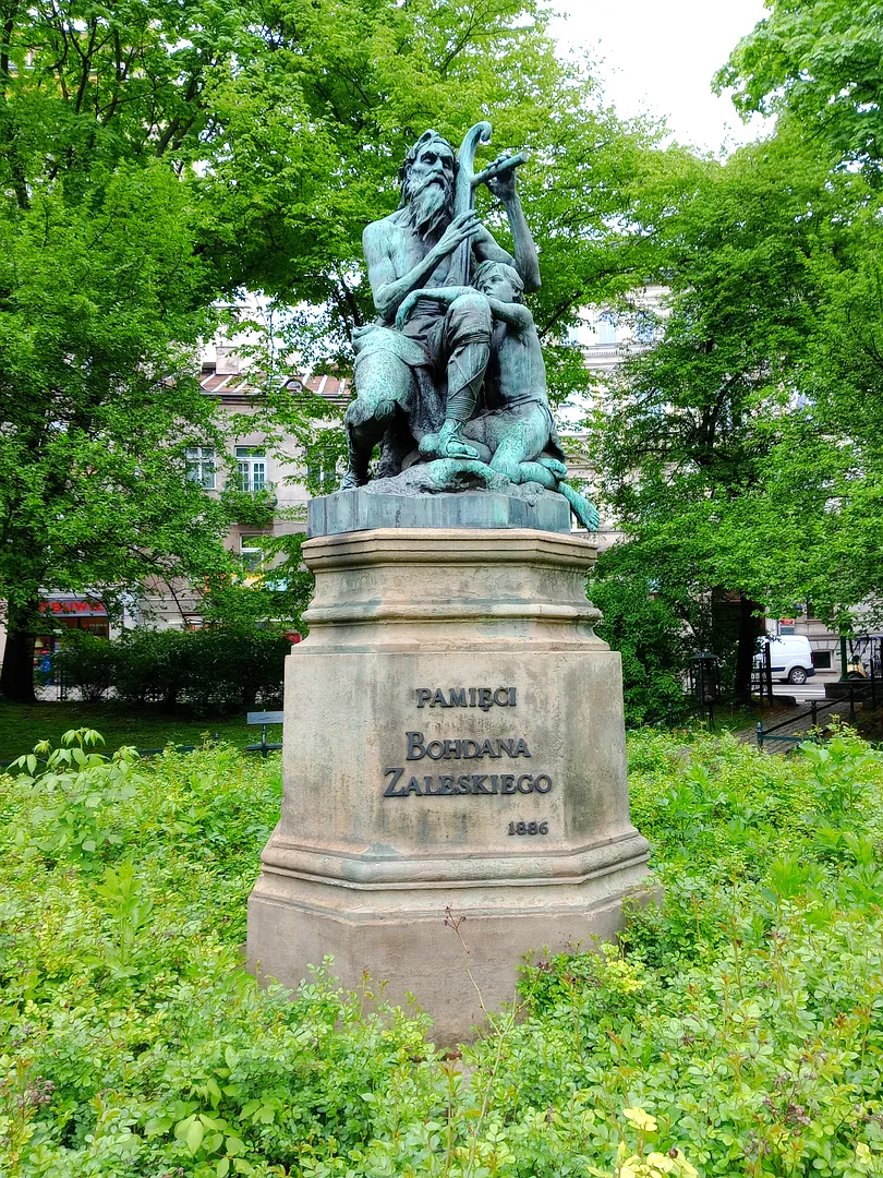 The figures above their inscribed base at Harpist monument