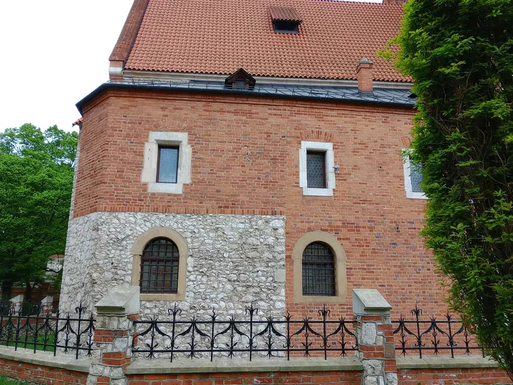 The brick church beside its railing at Holy Cross Church, Kraków
