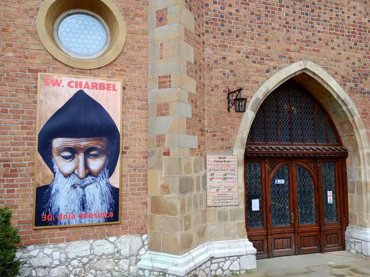 The entrance and its neighbouring plaque at Holy Cross Church, Kraków