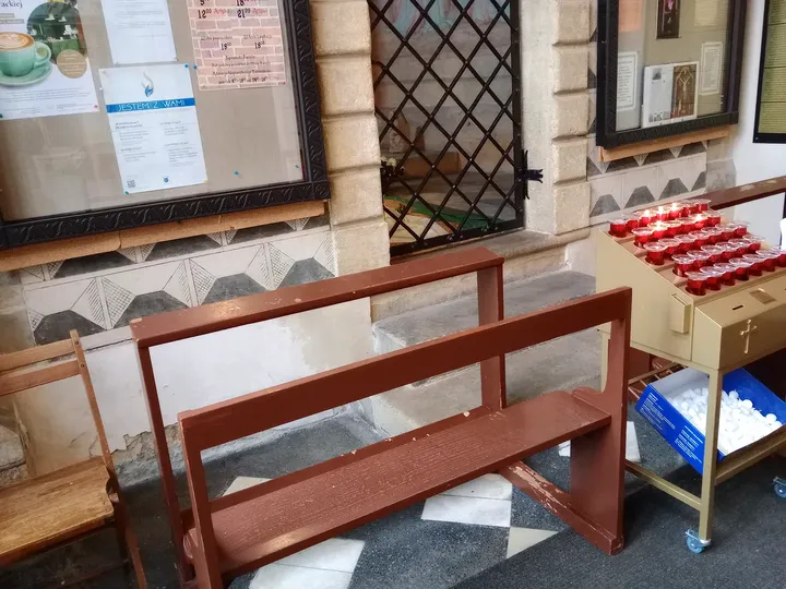 A wooden bench by the doorway at Holy Cross Church, Kraków