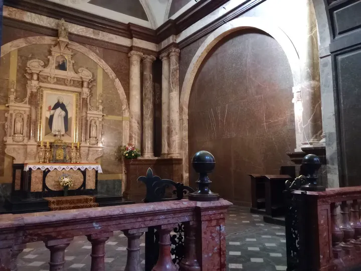 A side altar beneath a painted arch at Holy Trinity Basilica, Kraków