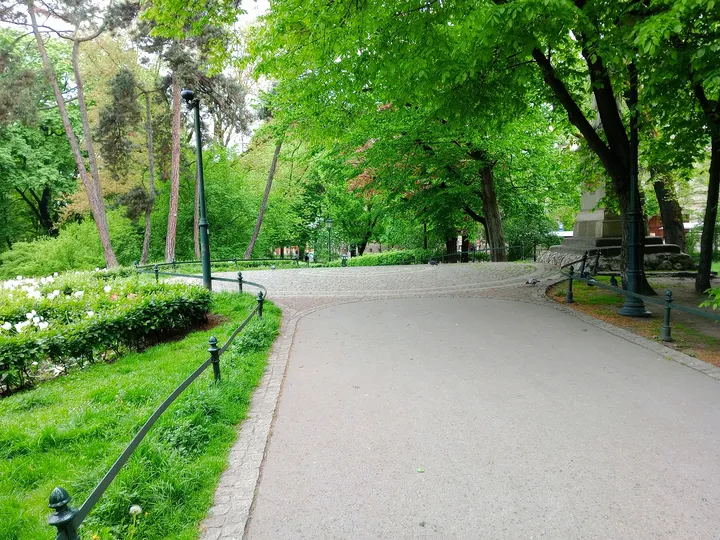 The broad avenue through spring greenery at Jadwiga and Jagiełło monument