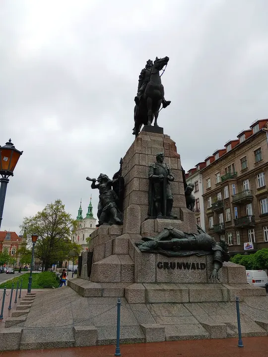 Sculpted figures below the mounted statue at Jan Matejko Square