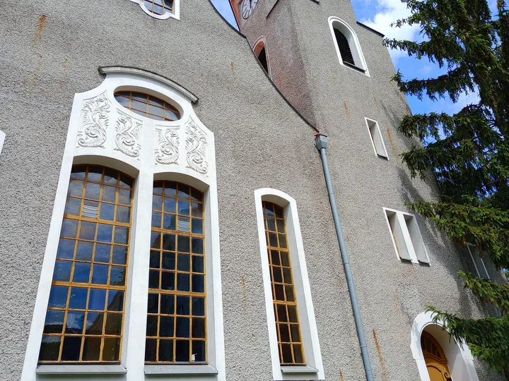 Tall windows beneath white stone arches at Jesus Church, Zielona Góra