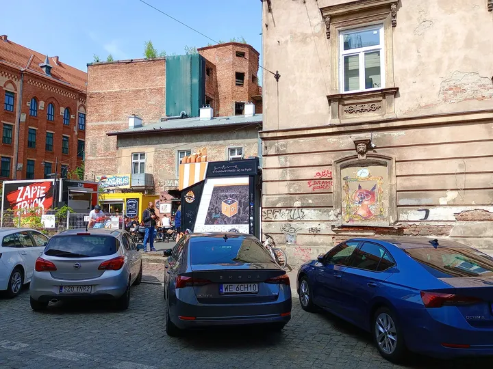 Food stalls behind the parked cars at Judah mural