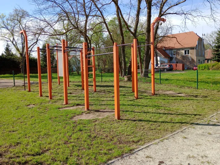 Wide view across the orange equipment at Kiełpin outdoor exercise ground