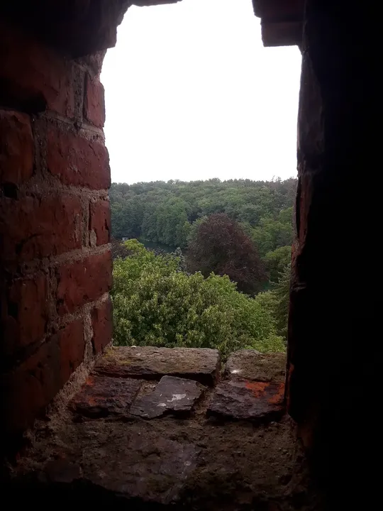 Landscape framed by the brick opening at Knights Hospitaller Castle, Łagów