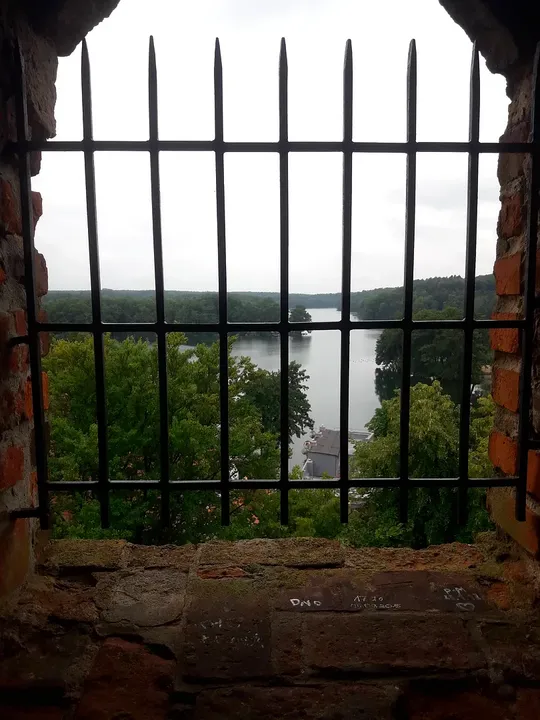 Lake seen through the tower grille at Knights Hospitaller Castle, Łagów