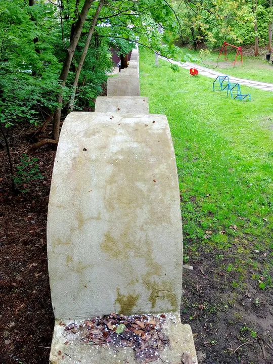 Stone marker near the grass at Kraków ghetto wall