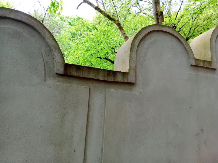 Wall segments beneath the trees at Kraków ghetto wall