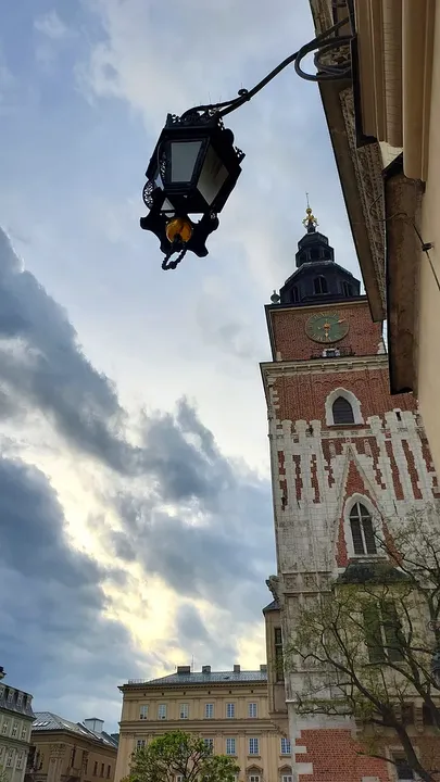 The tower beyond a hanging street lamp at Kraków Town Hall Tower
