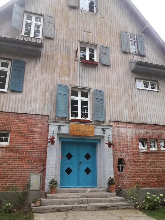 A blue doorway beneath upper windows at Lecha neighbourhood, Łagów
