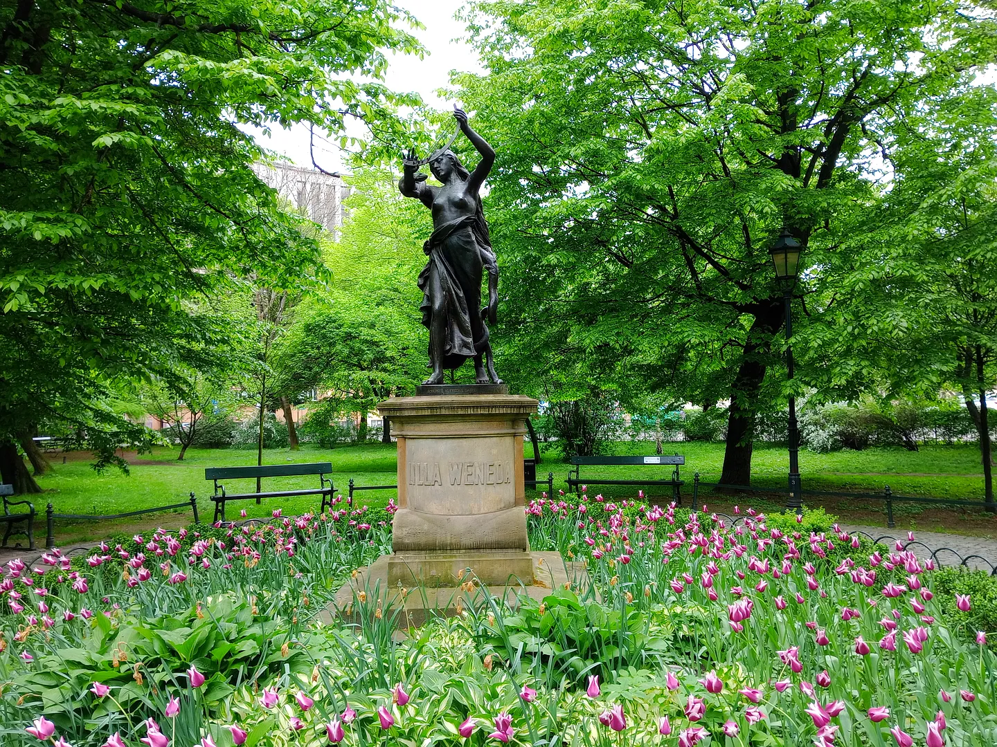 The statue above the spring flower bed at Lilla Weneda monument