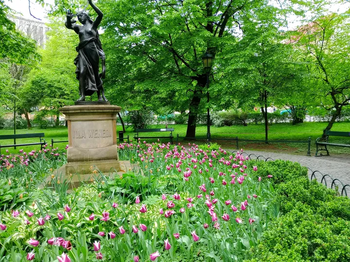 The statue beside the curved garden edge at Lilla Weneda monument
