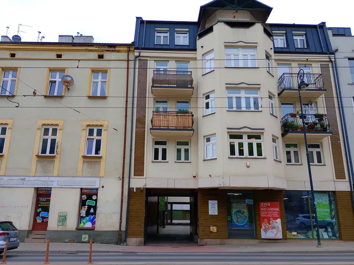 A decorated façade above street-level shops at Limanowskiego Street
