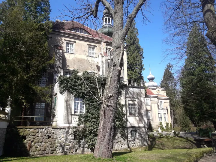 The palace façade beyond the lawn at Manor Park, Iłowa