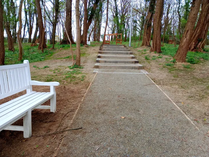 Broad gravel avenue with white benches at Manor Park, Świdnica