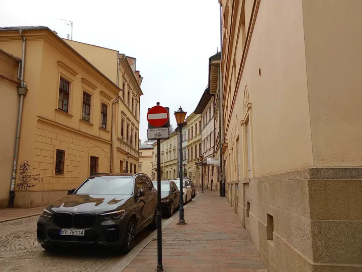 The narrow lane along the pale wall at Mikołajska Street
