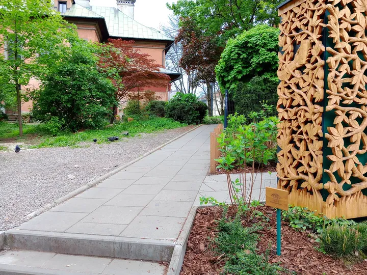 A narrow passage beside a patterned screen at Miodowa Street