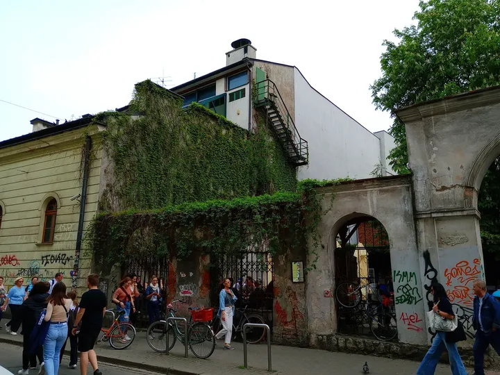 The entrance under a green awning at Mleczarnia courtyard