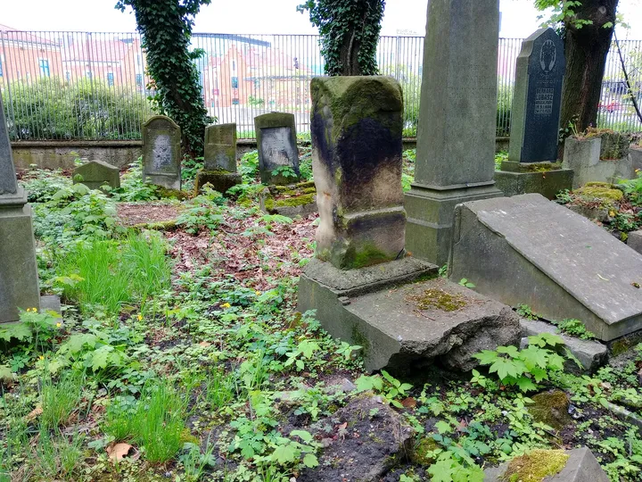 Broken stone fragments beside a grave at New Jewish Cemetery, Kraków